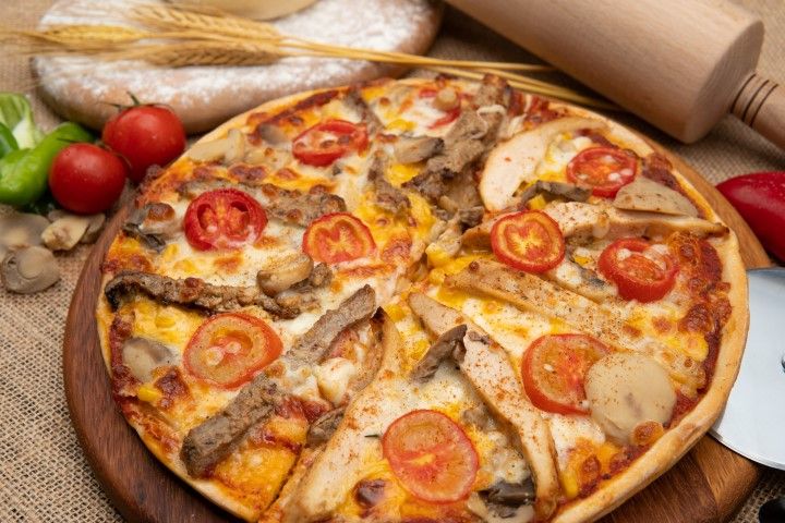 TAVUKLU PİZZA - Ev yapımı pizza hamuru, özel pizza sosu, mozarella, ızgara tavuk bonfile dilimleri, kokteyl domates, köy biberi kapya özel pizza baharatı ile.