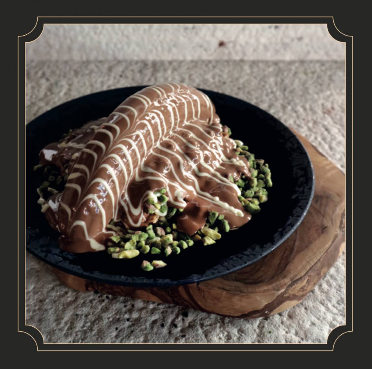 Mualla - Belçika Waffle üzerine beyaz çikolata, baklavalık Antep fıstığı, muz ve sütlü çikolata // Banana, white chocolate, pistachio and milk chocolate on a Belgian waffle 30 dakika içinde tüketiniz. Aksi halde çikolata donmaktadır. // Please consume in 30 minutes. Otherwise chocolate nets solid.