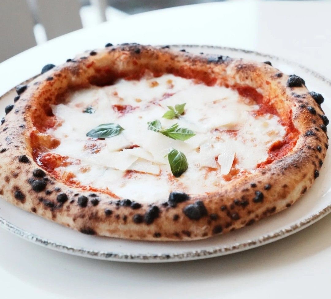Margherita - Domates sosu, taze fesleğen ve mozzarella ile hazırlanır.