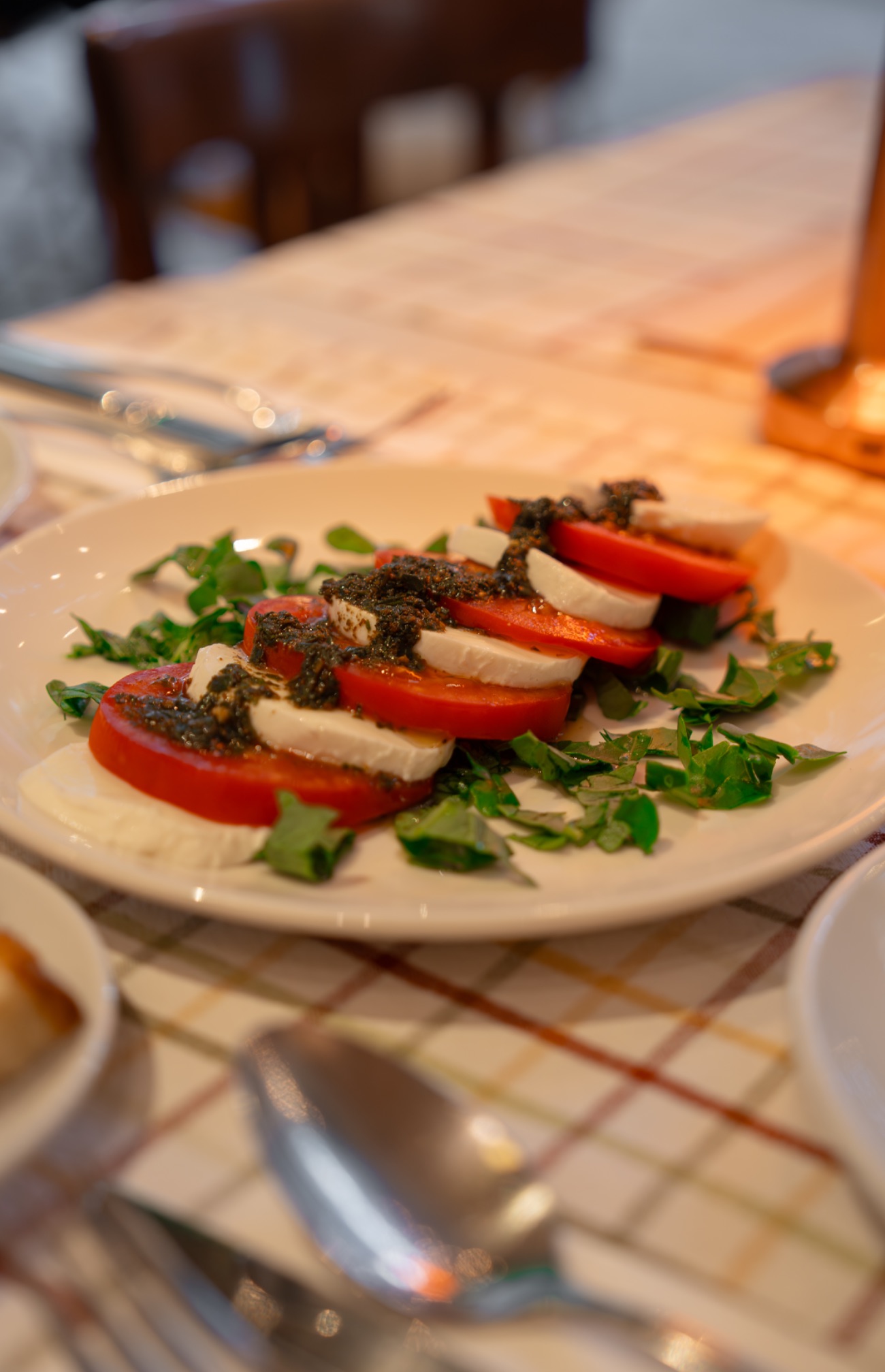 Caprese Pomodori e Ciliegine di Mozarella - Tomato salad topped with mozarella balls, pesto sauce and basil leaves