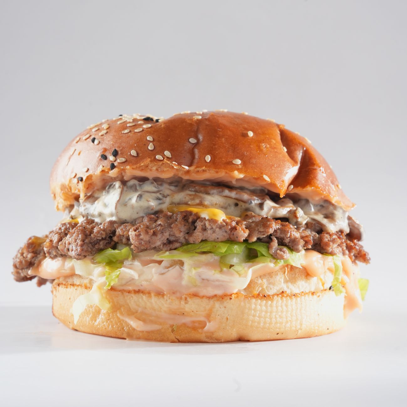 ترافل - صمون .  شريحة سماش لحم بقري . جبن شيدر . صلصة الفطر . خس . صلصة سموك