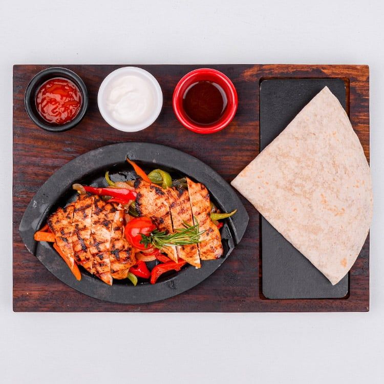 Tavuk Fajita - Sotelenmiş taze biber, kuru soğan ve havuç üzerine ızgarada pişirilmiş tavuk bonfile dilimleri, özel soslar ve tortilla ekmeği ile