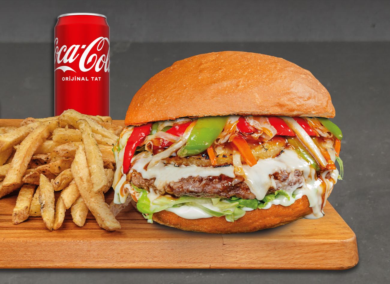 New Teriyaki Burger - Mayonez, marul, kırmızı soğan, domates, turşu ve teriyaki sosla kaplı bize özel 200g kaburga burger köftemiz üzerine eritilmiş Swiss peyniri, ızgara ananas, teriyaki sosla sotelenmiş havuç, lahana, kırmızı ve yeşil biber.