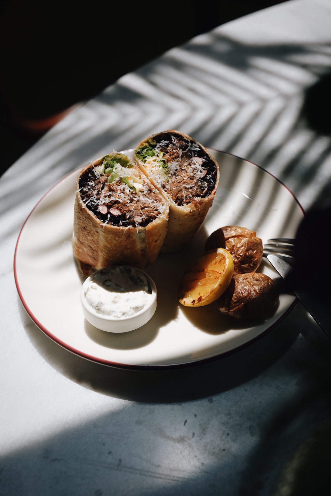 Mexican Burrito - Tortilla ekmeği içerisinde siyah pirinç, tiftik et, karamelize soğan, cheddar peyniri, salsa, acı ballı fasulye, marul ve basic sos ile hazırlanır; fırın patates ve jalapeño sos eşliğinde servis edilir.