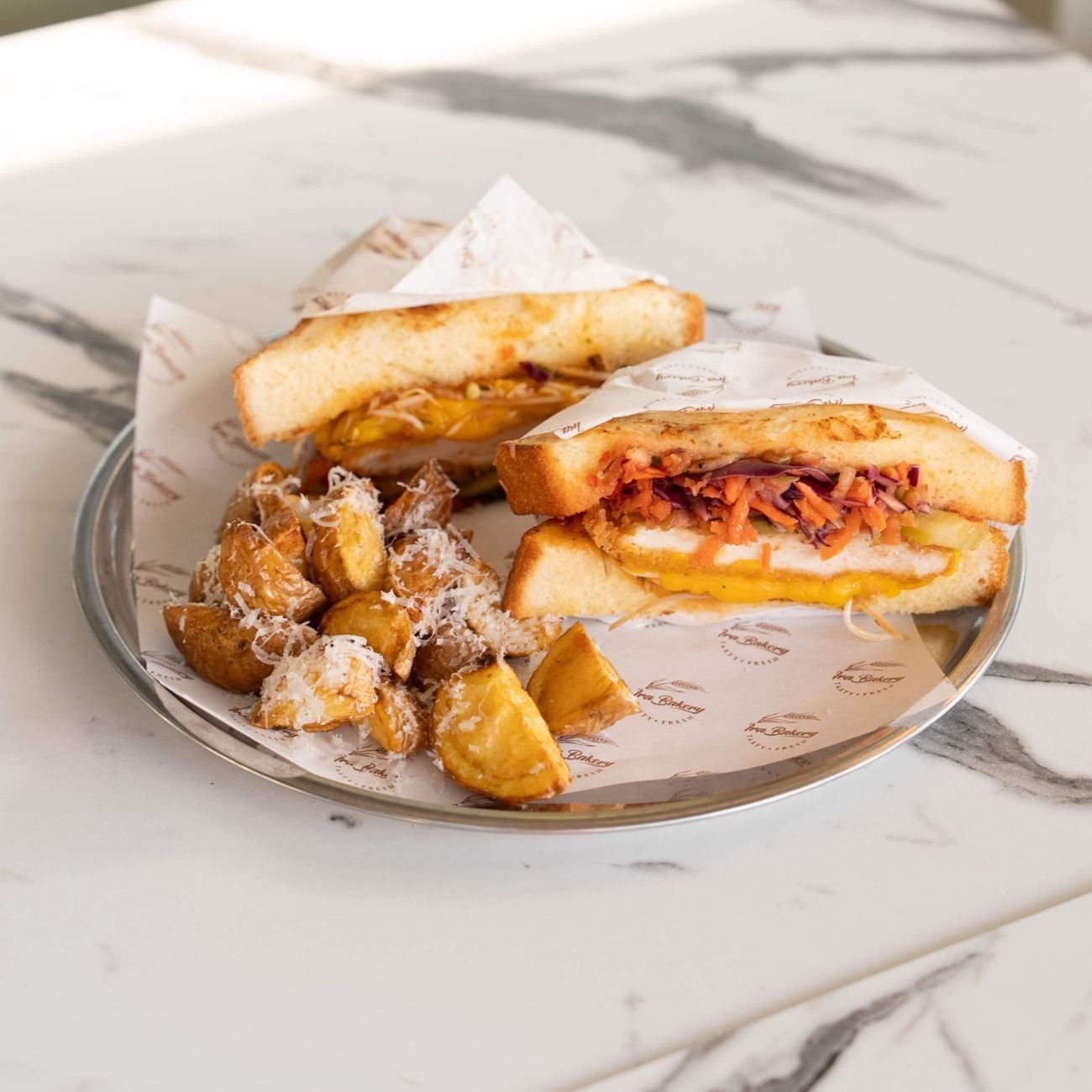 Sweet Chili Sando - Brioche Ekmeği, Sweetchili Sos, Panelenmiş Tavuk, Cheddar Peynir, Akdeniz Yeşilliği, Sebze Mix, Alman Turşusu. Yanında Fırında Patates ile servis edilir.