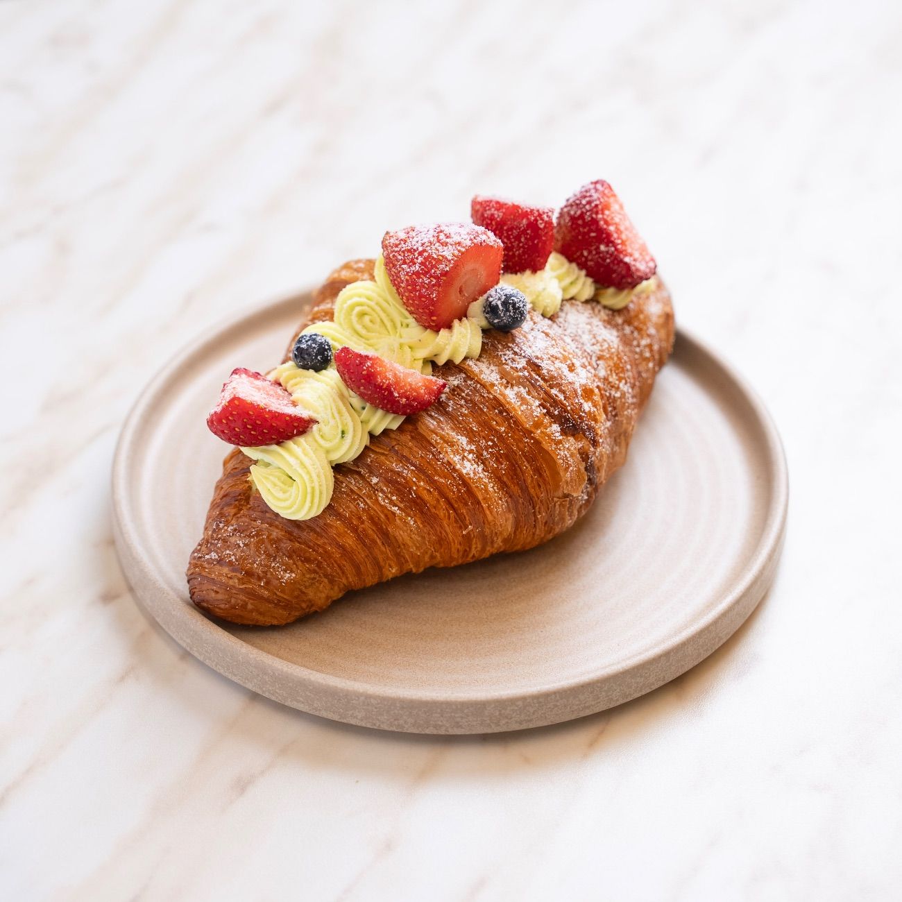 Fıstıklı Kruvasan - Antep Fıstıklı Pastacı Kreması, Çilek, Yaban Mersini. Yanında Belçika Çikolatası ile servis edilir.