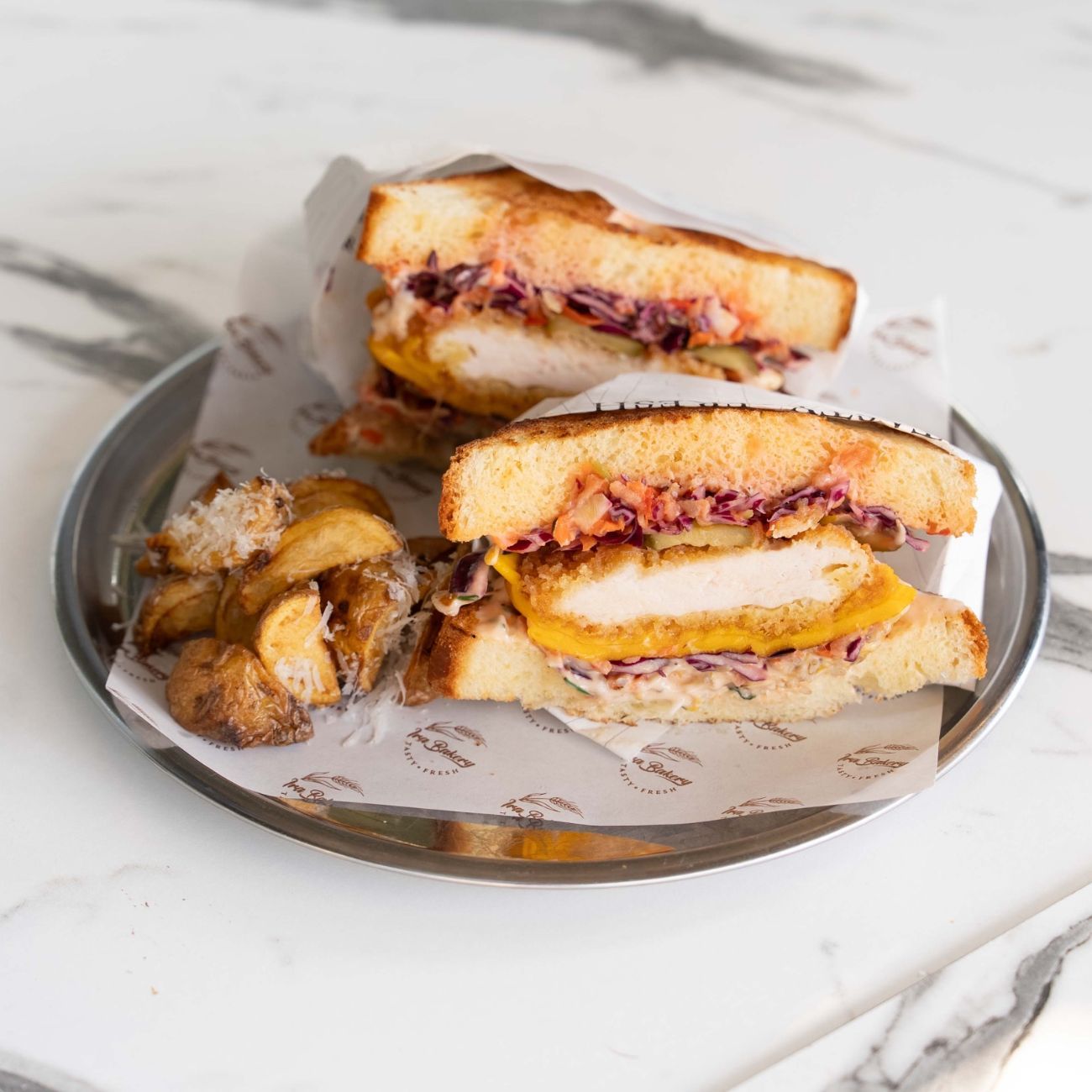 Sando Burn - Brioche Ekmeği, Acılı İra Sos, Sebze Mix, Alman Turşusu, Panelenmiş Çıtır Tavuk, Cheddar Peynir. Yanında Fırında Patates ile servis edilir.