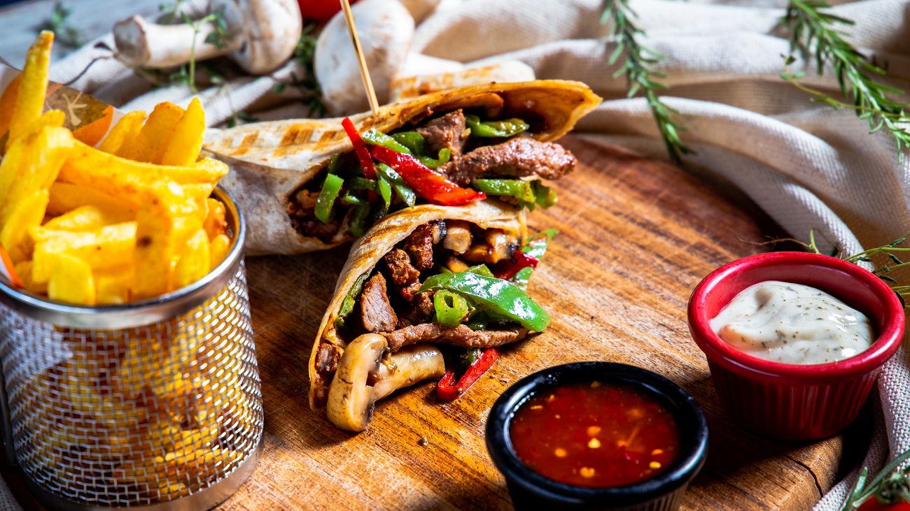 Et Dürüm - Tortilla ekmeği içerisinde,sotelenmiş biftek parçaları,yeşil biber,kırmızı biber,mantar,kuru soğan,kaşar peyniri,baharatlı patates kızartması,garlıc sos ve sweet chıllı sos ile…