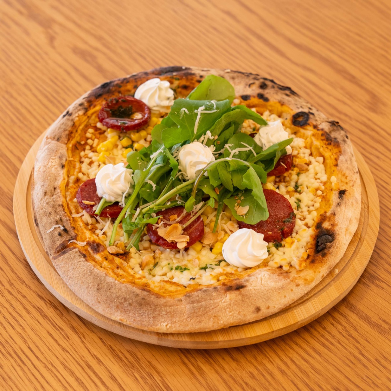 SUCUKLU MISIRLI PİZZA - Ekşi mayalı pizza hamuru üzerine domates sos, rende mozeralla, sucuk, mısır, roka, pesto sos, ekşi krema.