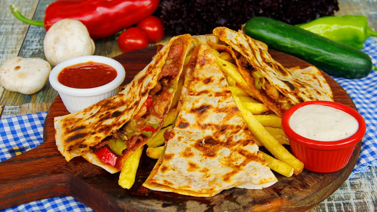 ETLİ QUESADILLA - Tortilla ekmeği içerisinde,sotelenmiş biftek parçaları,yeşil biber,kırmızı biber,mantar,kuru soğan,jalapeno biberi,Meksika fasülyesi,cheddar peyniri,baharatlı patates kızartması,garlıc sos ve sweet chıllı sos ile…