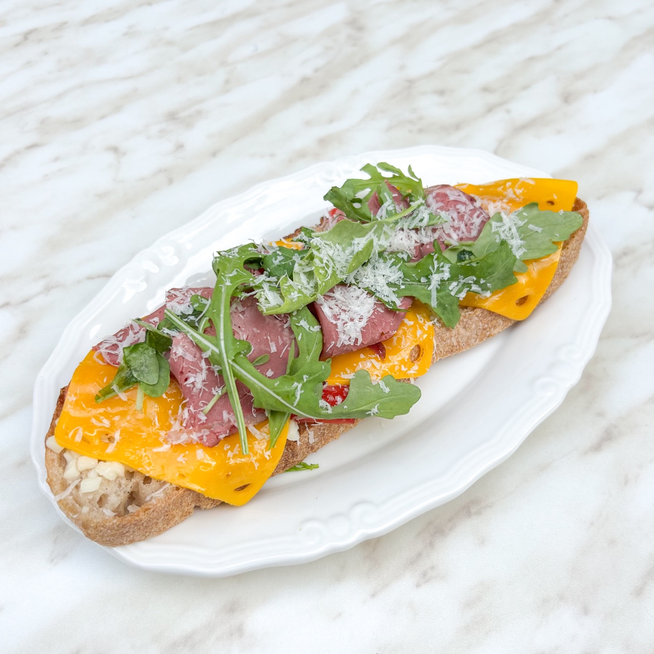 Roast Beef Cheddar Ekmeküstü - Roast Beef Füme Et, Ekşi Mayalı Ekmek, Cheddar Peyniri, Mozarella Peyniri, Köz Kapya Biberi, Rakula, Parmesan.