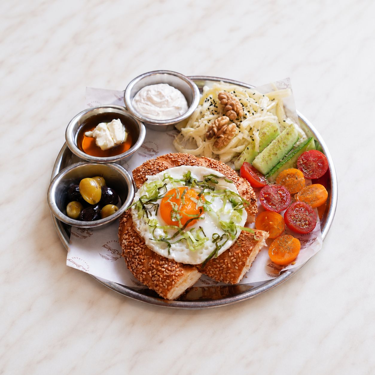 Simit Kahvaltı Tabağı - Simit, Göz Yumurta, Domates, Salatalık, Bal Kaymak, Peynir Sos, 2 Çeşit Zeytin, Kaşar Peynir, Beyaz Peynir, Çeçil Peynir, Ceviz.