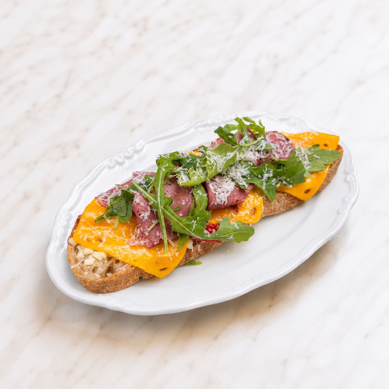 Roast Beef Cheddar Ekmeküstü - Roast Beef Füme Et, Ekşi Mayalı Ekmek, Cheddar Peyniri, Mozarella Peyniri, Köz Kapya Biberi, Rakula, Parmesan.