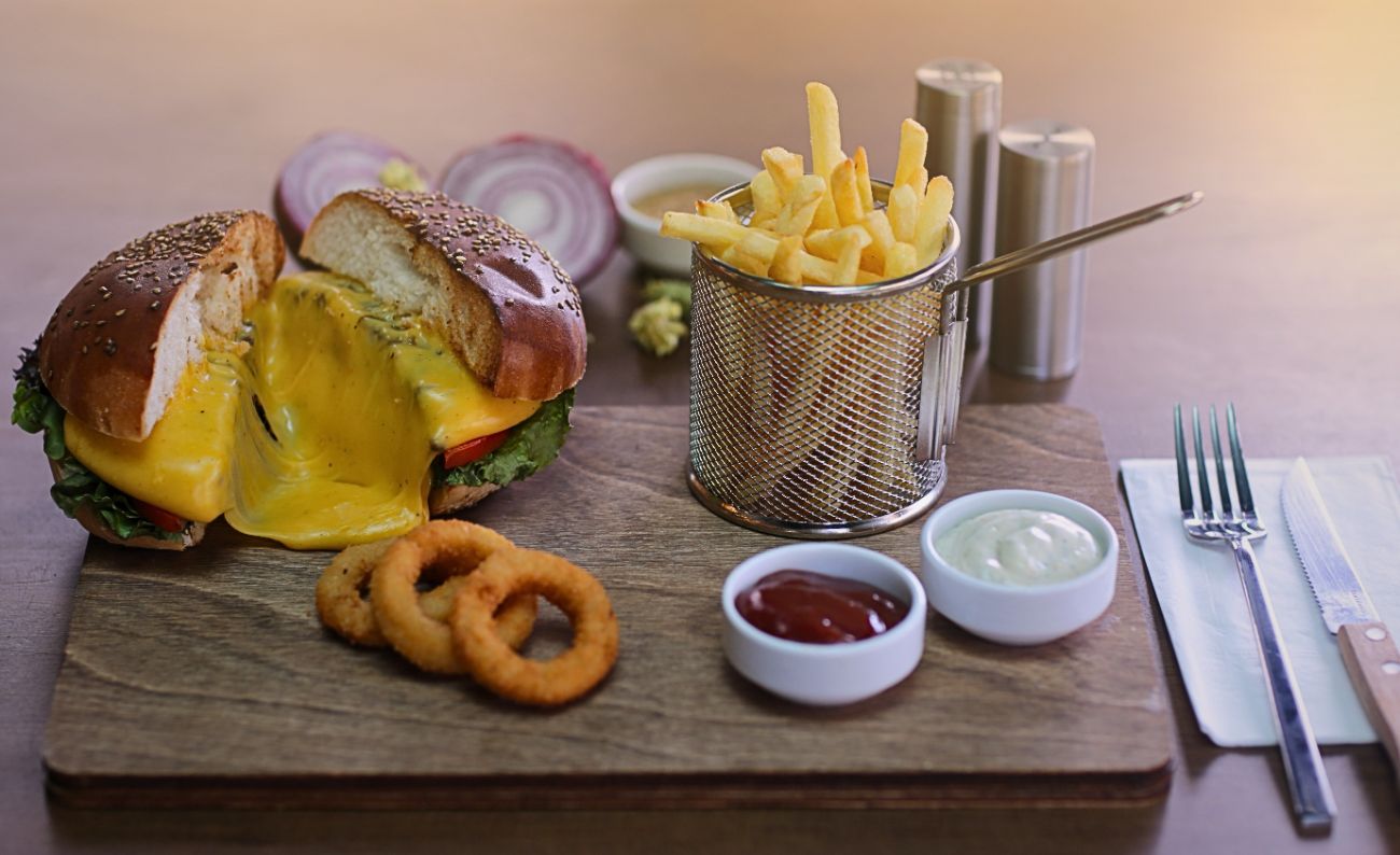 JOLİ JARDİN BURGER - 150gr Hamburger Köfte, Joli Jardin Hamburger Sos, CheddarPeynir, Karamelize Soğan, Jambon,  Patates Cipsi, Soğan HalkasıKcal:1282,2 Pro:49,9 Karb:108,2 Yağ:167,94