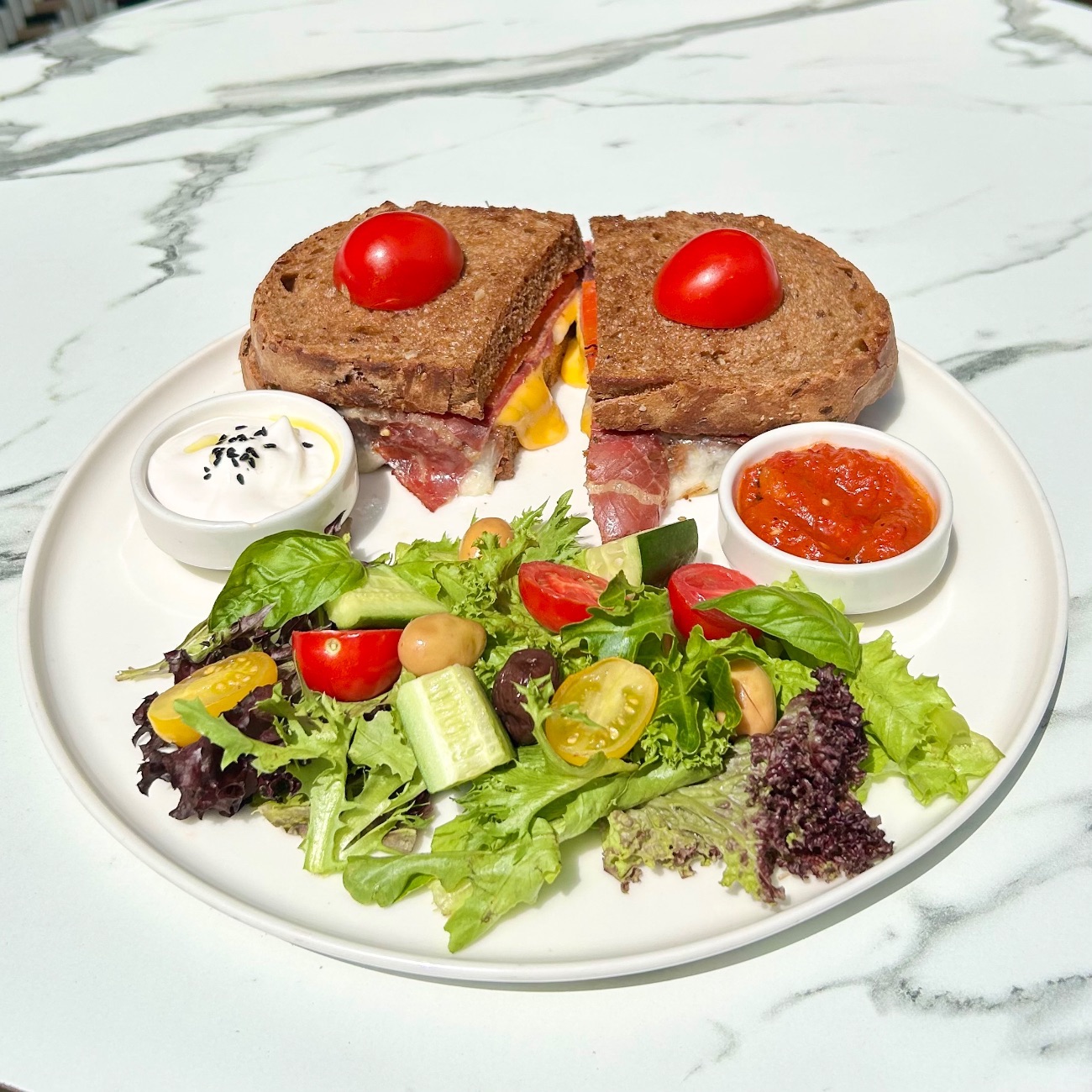 Roast Beef Cheddar Ekmeküstü - Kızarmış Ekşi Mayalı Ekmek, Cheddar Peynir, Roast Beef, Mozarella, Közlenmiş Kapya Biber. Yanında Peynir Sos ve Acuka ile servis edilir.