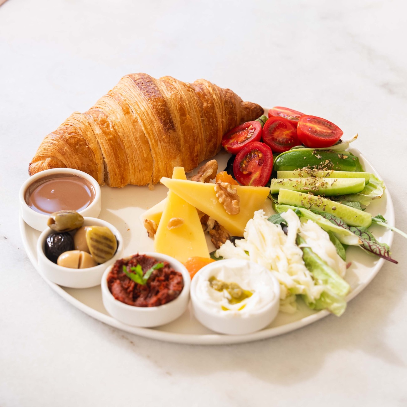 Kruvasan Ekspress Kahvaltı - Kruvasan, Ezine Peynir, Kaşar Peyniri, Örgü Peynir, Salatalık, Çeri Domates, Kuru Domatesli Peynir Sos, Acuka, 3 Çeşit Zeytin, Belçika Çikolatası, Ceviz, Kuru Kayısı, Akdeniz Yeşilliği, 1 Bardak Çay