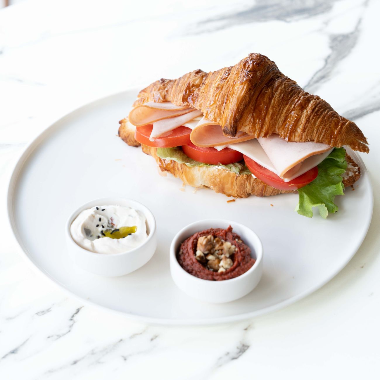 Hindi Füme Cheddarlı Kruvasan - Peynir Sos, Marul, Hindi Füme, Cheddar Peynir, Domates. Yanında Peynir Sos ve Acuka ile servis edilir.