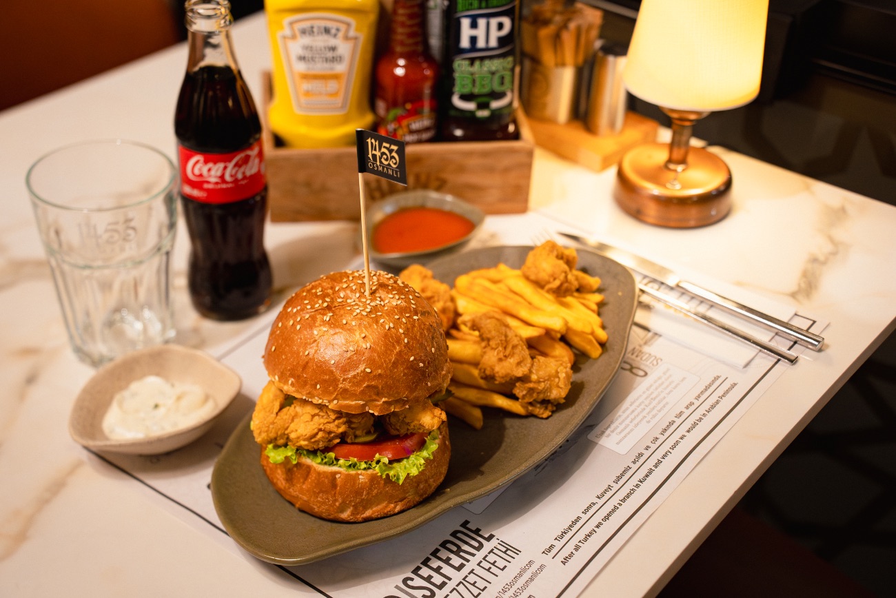 TAVUK KALAMAR BURGER - 200gr. Çıtır tavuk kalamar parçaları, kibrit patates, domates, kornişon turşu, marul, patates kızartması ve özel dip sos