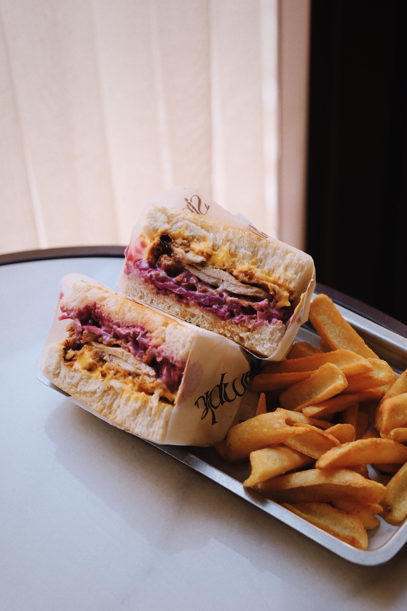 Chicken Sandwich - Homemade toast, fried chicken, coleslaw with red cabbage, cheddar cheese, spicy honey, and a spoonful of potatoes on the side.