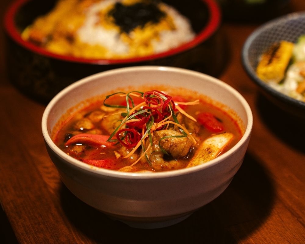 Tom Yum Çorba (Acılı) - Tavuk suyu, özel tom yum karışımı (acılı),  jumbo karides, yeşil soğan, surumi yengeç, cherry domates ve mantar