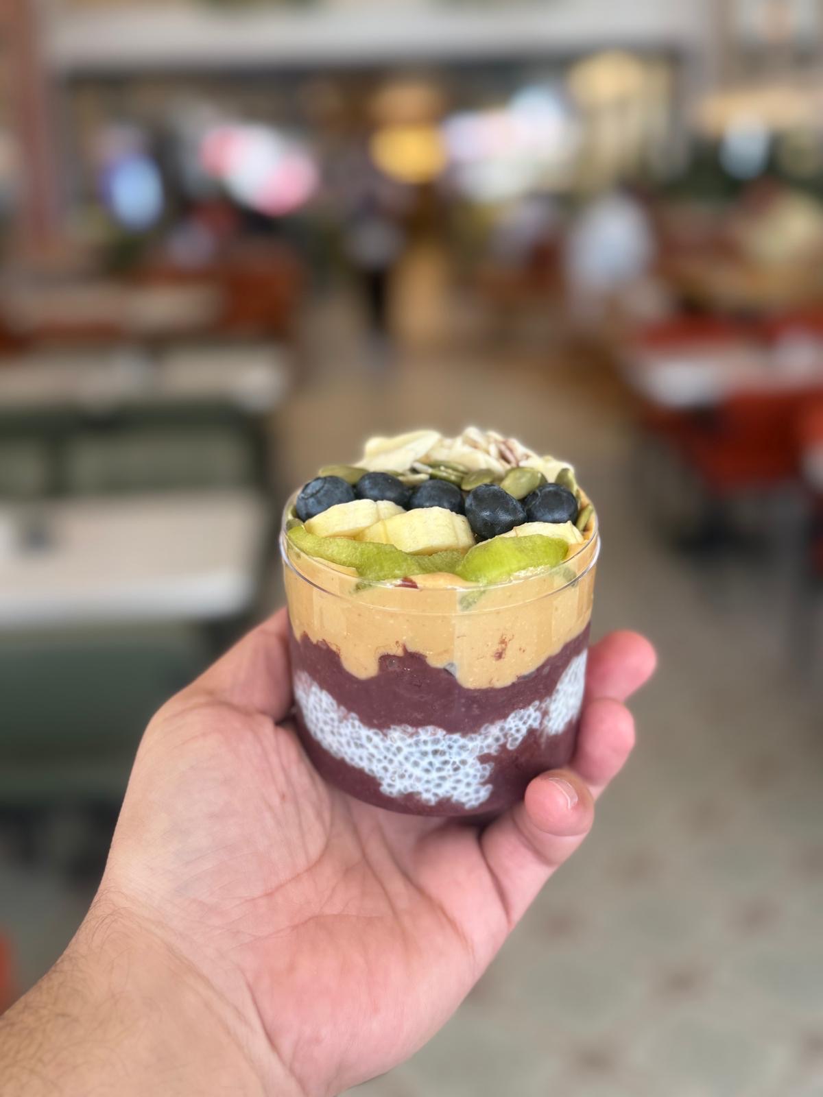 Yer Fıstklı Acai Cup - Gel-Al serviste sipariş alınmaktadır. Acai meyve püresi, muz, kivi, yer fıstığı kreması, yaban mersini, kabak çekirdeği, file badem, chia tohumu, yulaf.