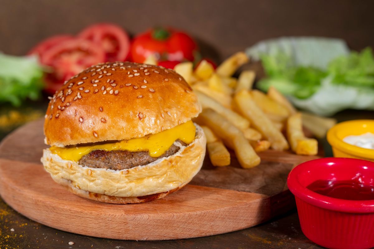 Cheddar Cheeseburger 90 Gr + Cips - Susamlı ekmek arasında ızgara hamburger, cheddar peyniri, domates, marul, salatalık turşusu, patates cips ve sos ile servis edilir.Paket ürün olduğu için görsel farklılık gösterebilir.