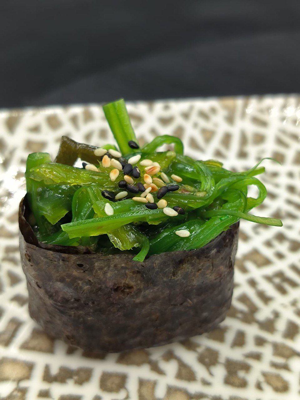 واکامه گونکان - Wakame Gunkan - یک گونکان با طراوت و پر جنب و جوش با سالاد جلبک دریایی چاشنی شده (wakame) در بالای برنج سوشی پیچیده شده در نوری - سبک، تند، و پر از بافت