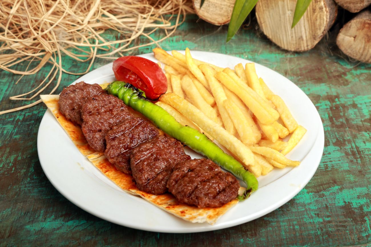 Izgara Köfte - 6 parça köfte, patates kızartması, Köz domates ve Köz biber ile servis edilir.