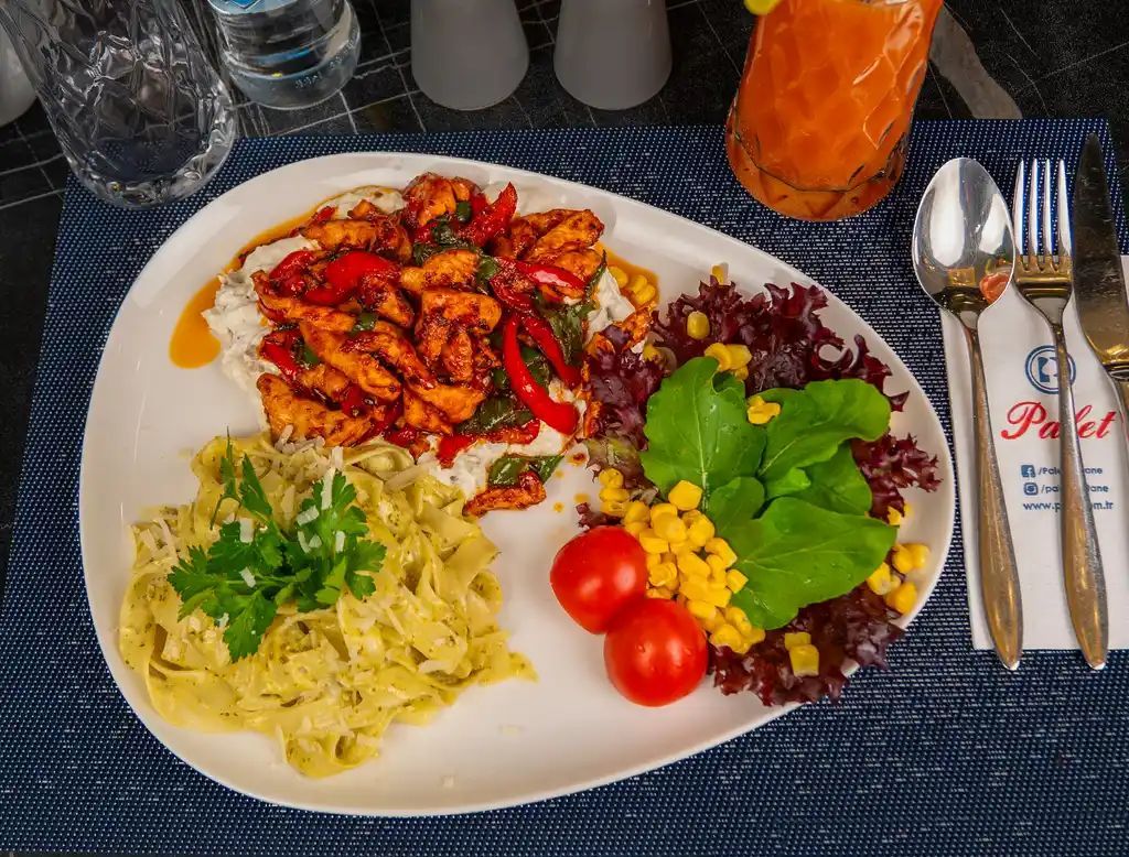 Tavuk Polenta - Jülyen tavuk dilimleri, kapya biber, köy biberi, napoliten sos; sote altına yoğurtlu patlıcanlı sos yanında pesto soslu süt için kremalı makarna ve salata ile servis edilir.