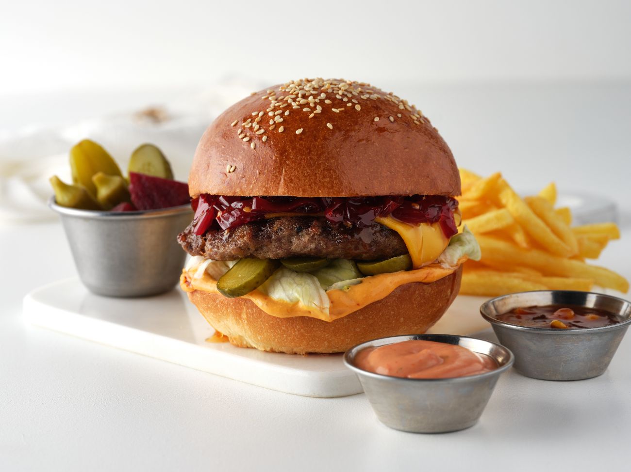 NO75's BURGER - 120 gr burger köftesi, peri peri sos, acı biber reçeli, cheddar, alman turşusu, ıceberg; patates kızartması, kokteyl sos, burger sos ve karışık turşu ile servis edilir.