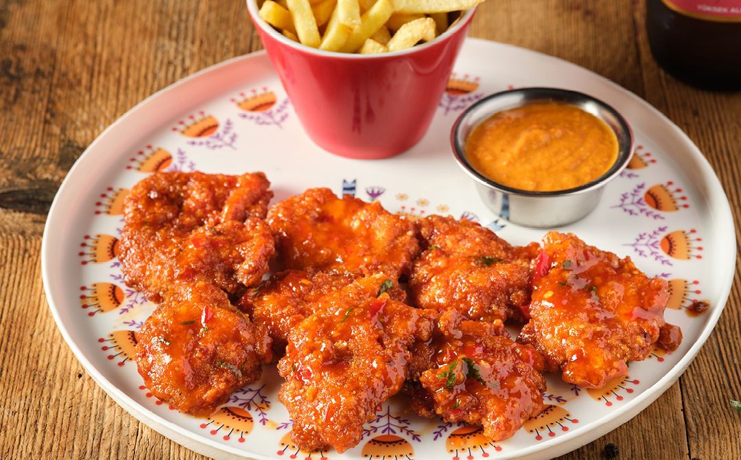 SWEET CHILLI TAVUK PARÇALARI - Sweet chilli sos ile panelenmiş tavuk parçaları, patates kızartması ve aioli sos ile servis edilir.