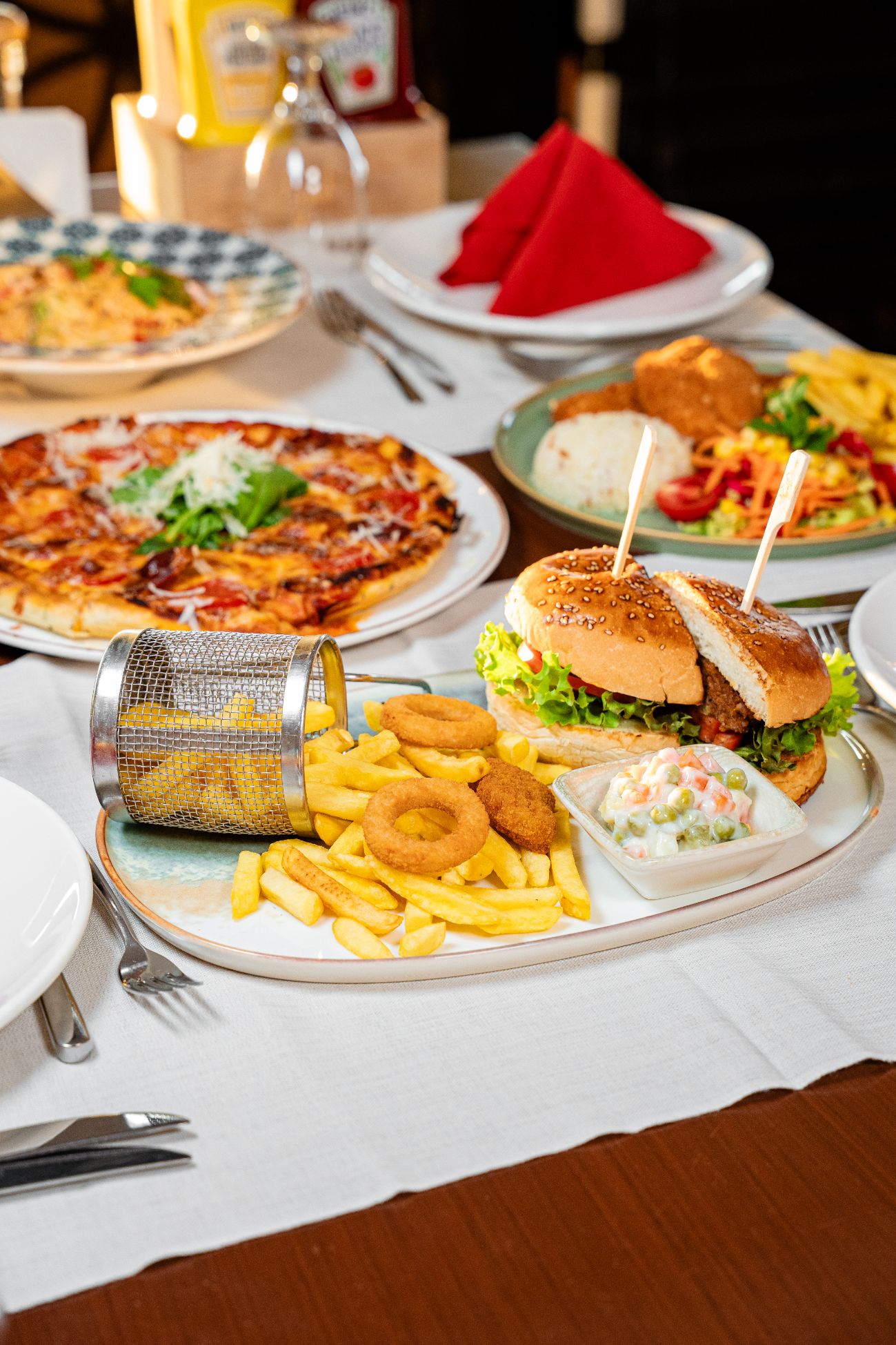 Hamburger - 120 gram Köfte, Domates, Turşu, Yeşillik, Özel Sos, Patates Cips, Soğan Halkası ve Nugget ile servis edilir.