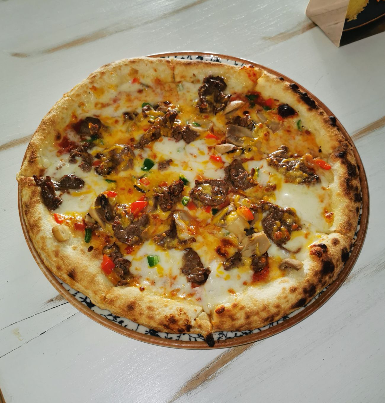 Time's special pizza - Pizza  sosu ve mozerella serilmiş pizza hamurunun üzerinde tavada sotelenmiş biftek dilimleri, biber, mantar ve cheddar peyniri