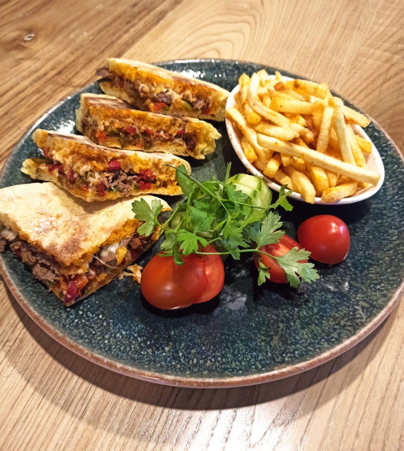 Bazlama Biftek Sandviç - Bazlama ekmeği arasında sotelenmiş biftek ve biberler, kaşar peyniri yanında baharatlı parmak patates