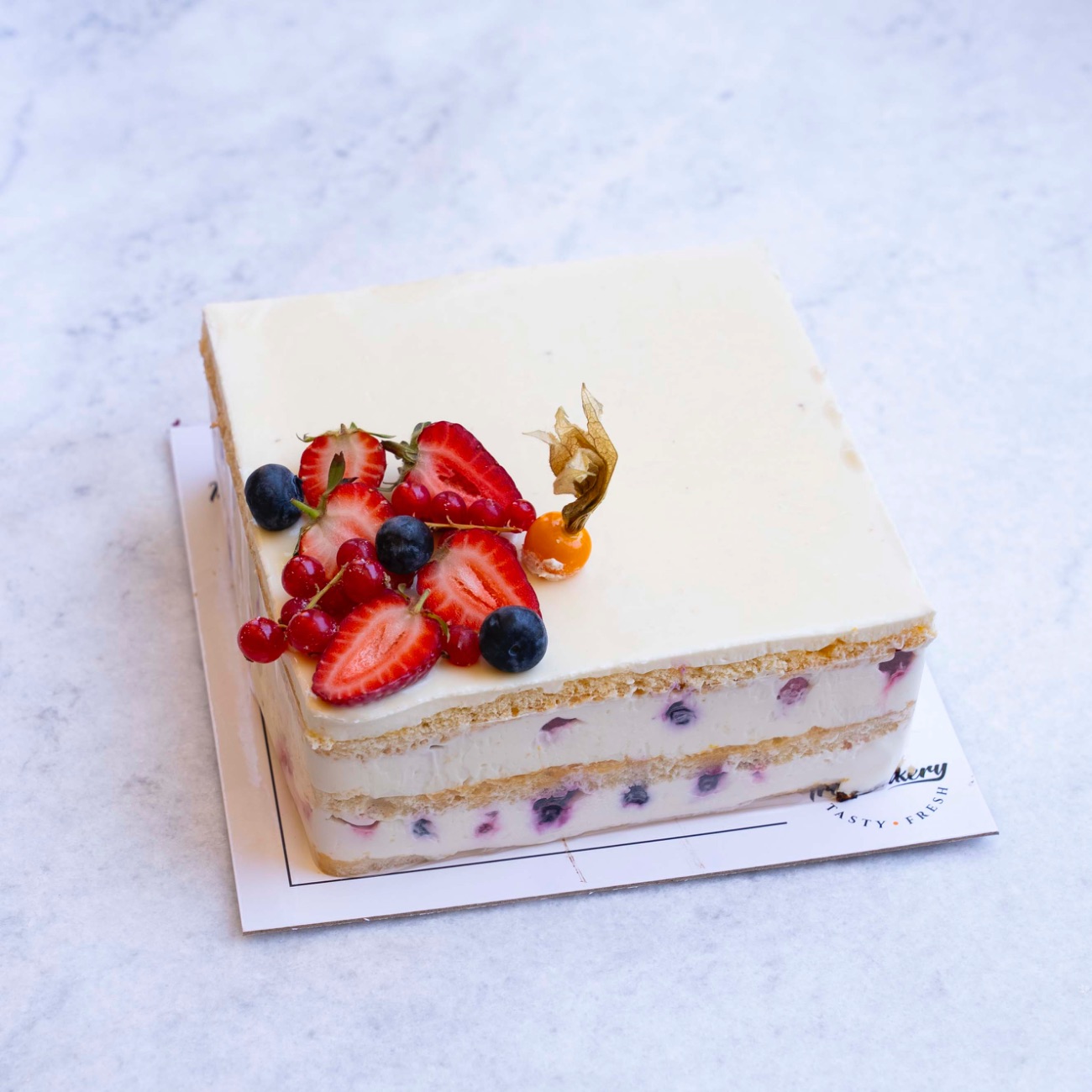 Lemon Cake (4-6 Kişilik) - Sade pandispanya, pastacı kreması, beyaz çikolatalı sos, çilek, frambuaz, yaban mersini, limon ve portakal suyu.