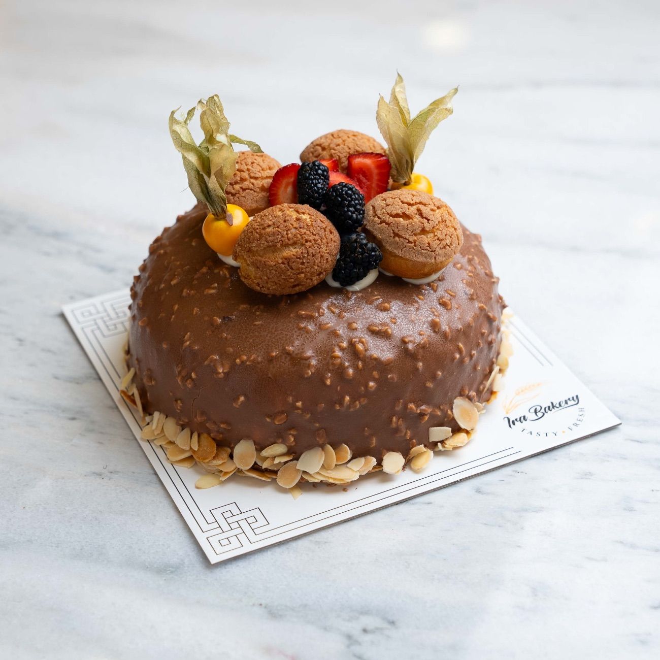 New York (6-8 Kişilik) - Çikolatalı krema, supangle, çilek, fıstık, profiterol hamuru, dışı sütlü fındık sos, çikolatalı pandispanya.