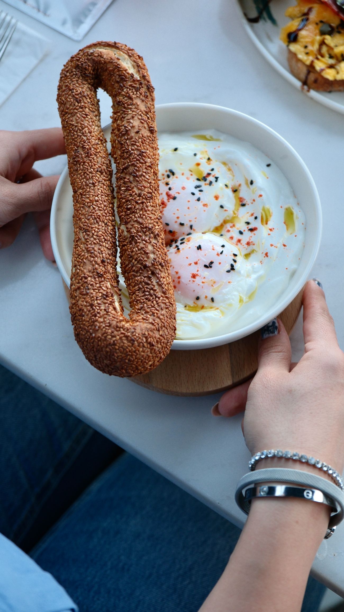 Çılbır - Strained yogurt, poached eggs, green oil, Jerusalem bagel.