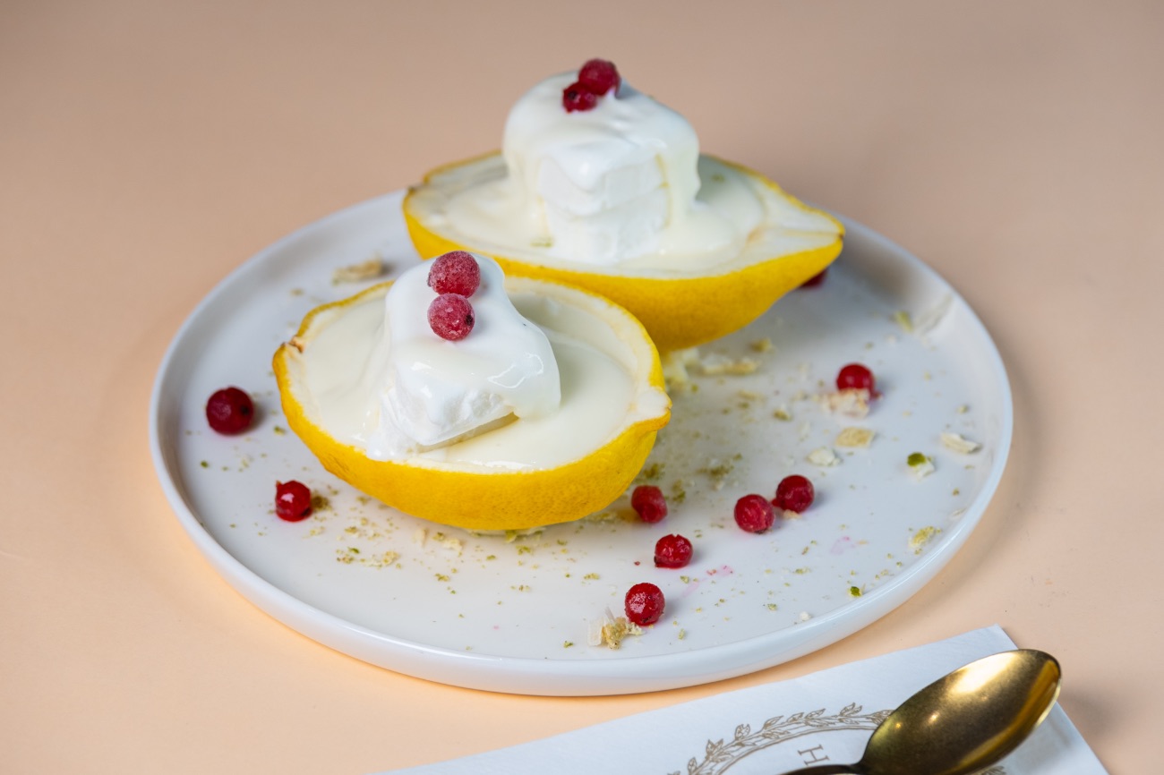 Halcyon Eksy - İnce limon kabuklarının içinde saklanan hafif ve kremsi dolgular, her lokmada ferahlık sunuyor. Üzerindeki orijinal limon sosu, vanilyalı dondurmayla buluşunca tatlıya nefis bir denge katıyor. Frenk üzümleriyle tamamlanan bu sunum, hem göz kamaştırıyor hem iç ferahlatıyor. Aynı zamanda II. Elizabethinde en sevdiği tatlıymış 🍋🍦🫐✨