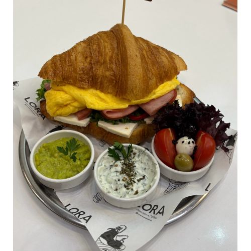 Füme Etli-Yumurtalı Kruvasan - Kruvasan arasında beyaz peynir kıvırcık marul kapya biber domates. Füme et - Yumurta(Omlet)- yanında avokado dipsos dere otlu yoğurt-domates top mozzarella ve zeytinler ile servis edilir.