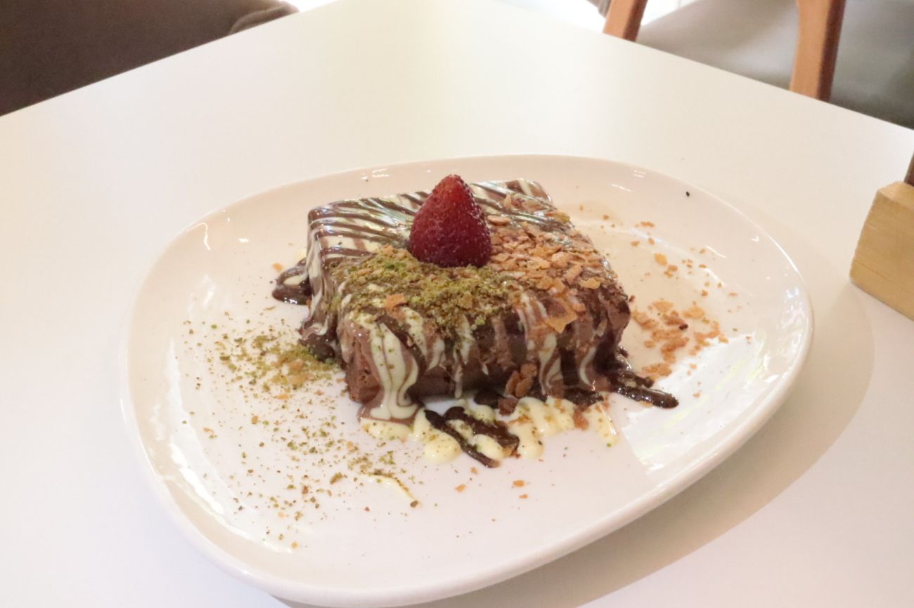 Browni (Yeni) - Taze browni üzerine Belçika çikolatası, antep fıstığı tozu, çilek ve krep kırığı ile servis edilir.