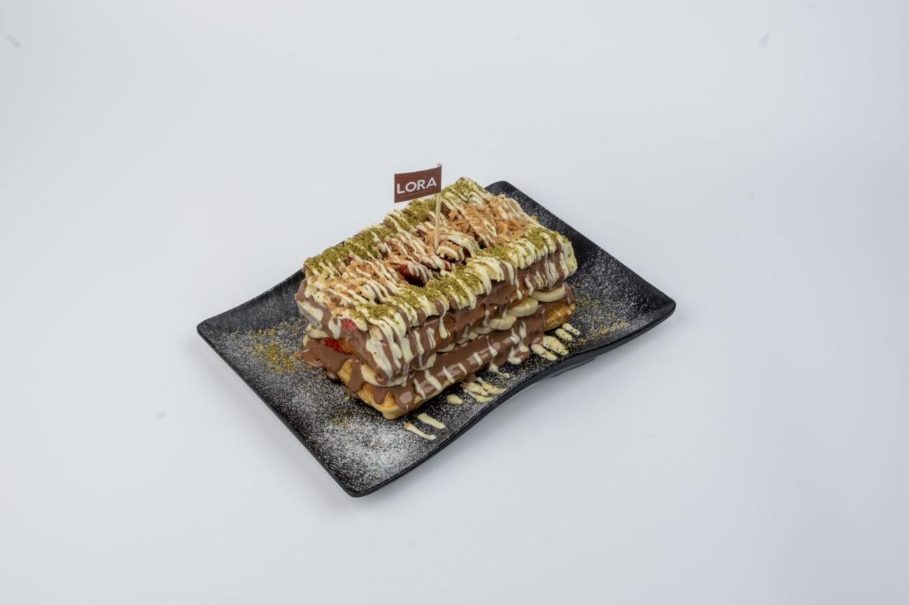 Double Waffle - İki waffle arasına bol çikolata, muz, çilek ve krep kırığı eklenir. Üzerine tekrar çikolata, muz, çilek, krep kırığı ve antep fıstığı parçaları eklenerek servis edilir. Dilerseniz ekstralar bölümden ekleme yapabilirsiniz.