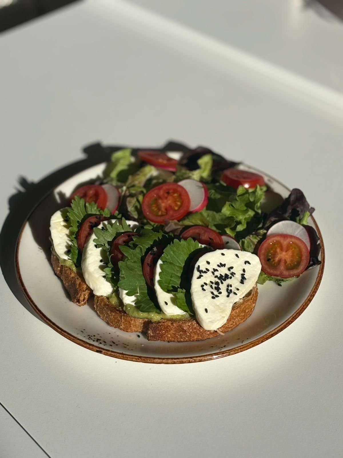 Caprese Tartine - Tereyağında kızartılmış ekşi mayalı ekmek, pembe domates, suda mozerella, roka, salata ve yeşil zeytin eşlikçileriyle...